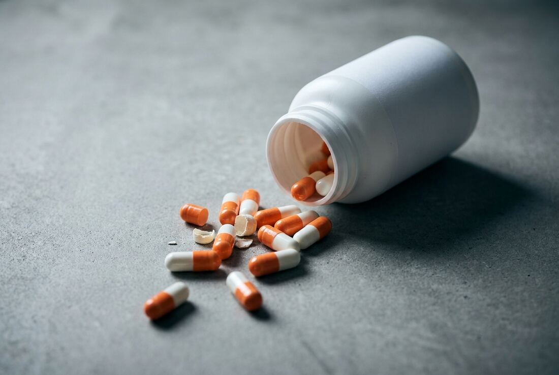 Loose unmarked capsules spilled from a supplement bottle